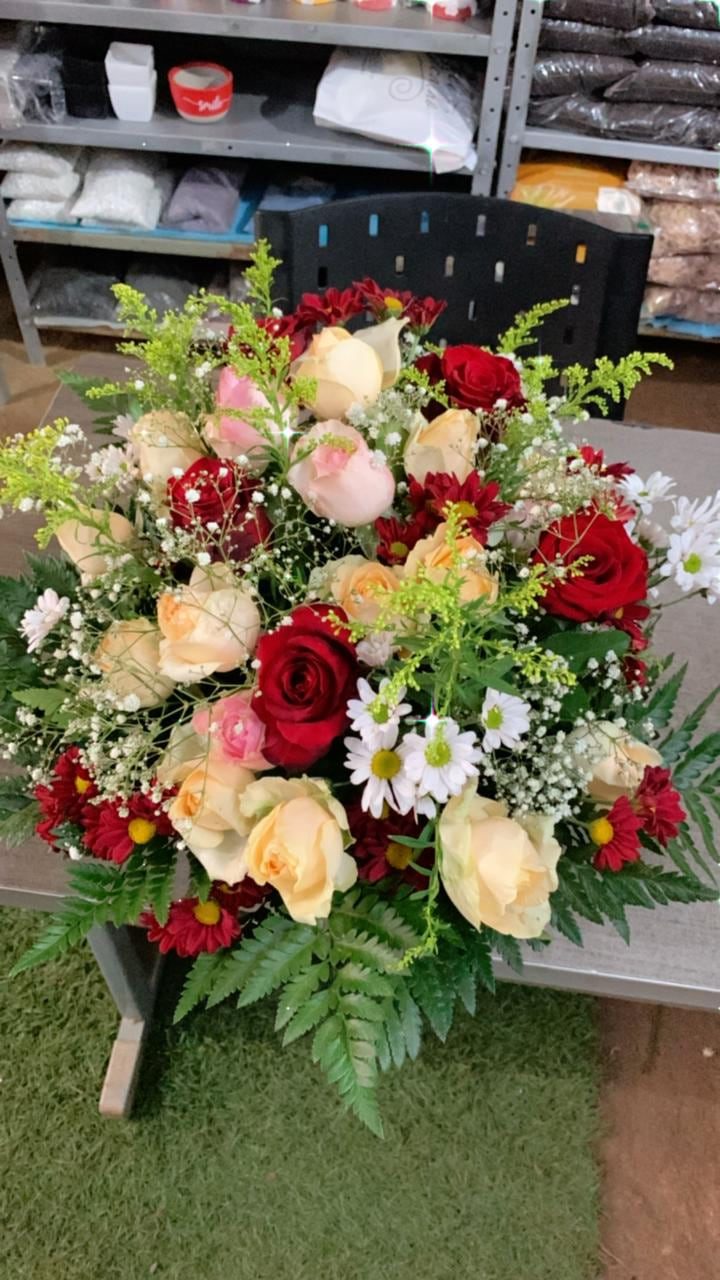 Arranjo floral com rosas, margaridas e folhagens